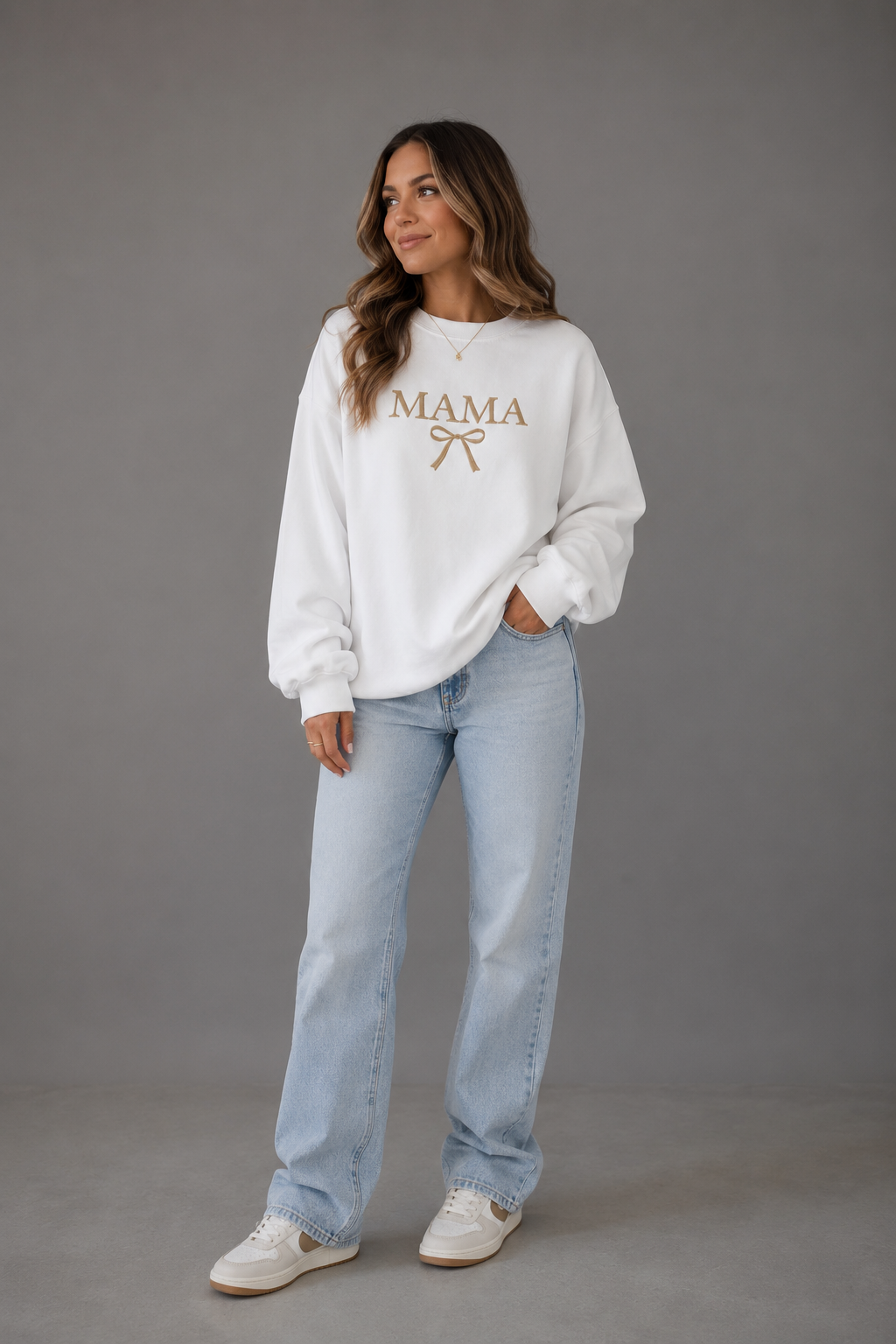 Woman wearing a white Mama bow sweatshirt from Soul Kreations Luxe with light wash jeans, front view. ✨