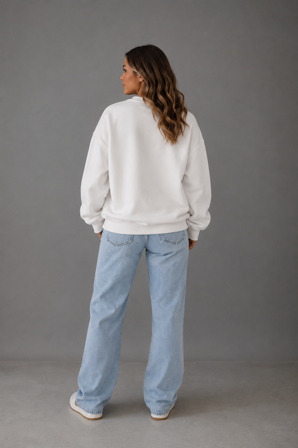 Back view of woman wearing a white oversized Mama sweatshirt from Soul Kreations Luxe with light wash jeans. ✨