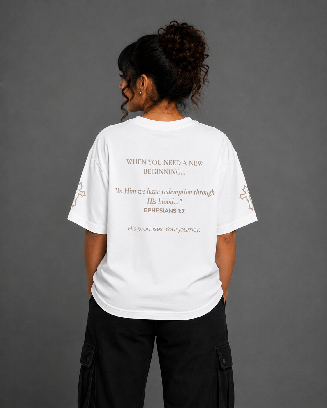 Back view of white Redeemed T-shirt from the Soul Kreations Luxe Promise Collection featuring Ephesians 1:7 scripture and embroidered cross sleeve details.