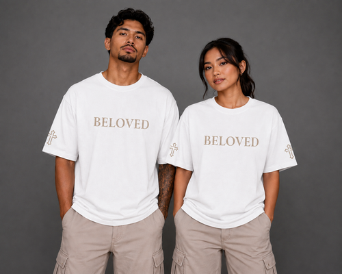 Male and female models wearing white Beloved T-shirts with embroidered Beloved lettering and cross sleeve details from the Soul Kreations Luxe Promise Collection. ✨