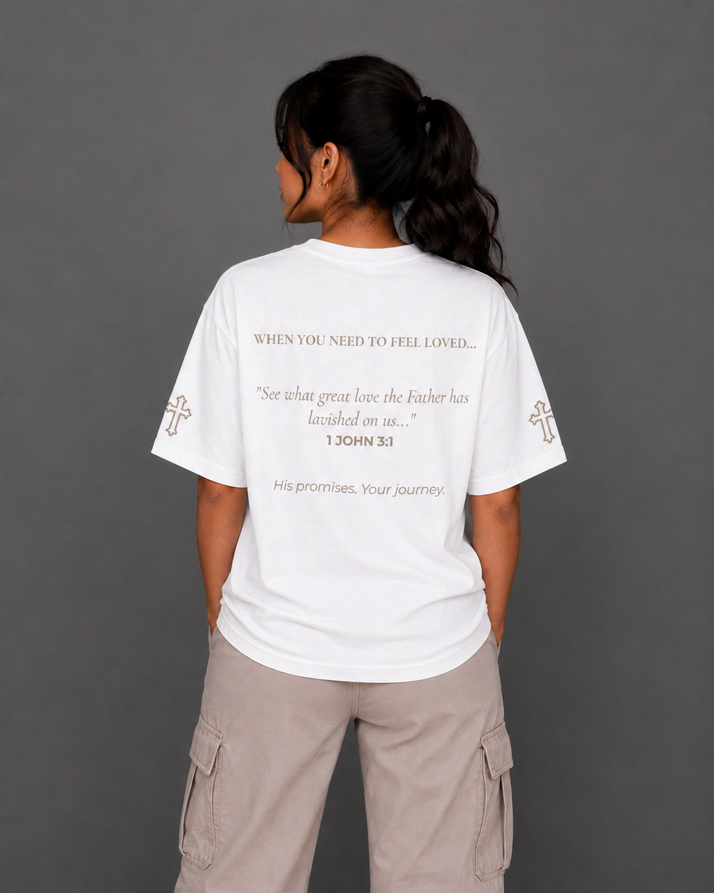 Back view of white Beloved T-shirt from the Soul Kreations Luxe Promise Collection featuring 1 John 3:1 scripture and embroidered cross sleeve details. ✨