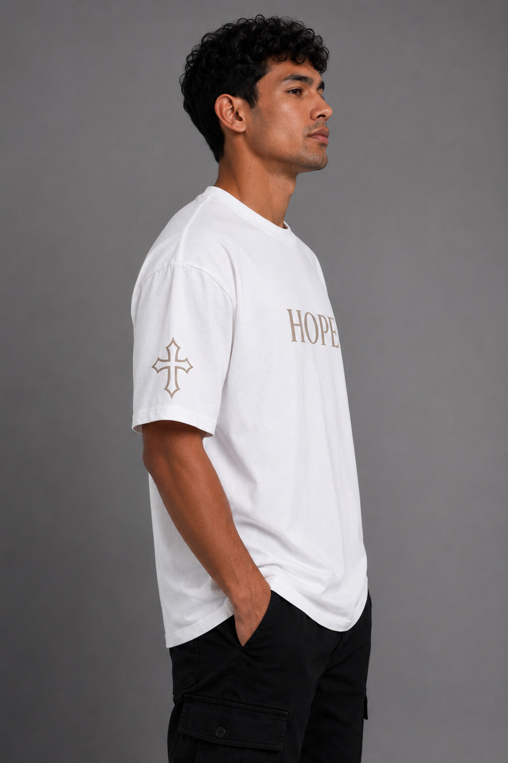 Male model wearing white Hope T-shirt with embroidered HOPE chest design and embroidered cross sleeve detail from the Soul Kreations Luxe Promise Collection.
