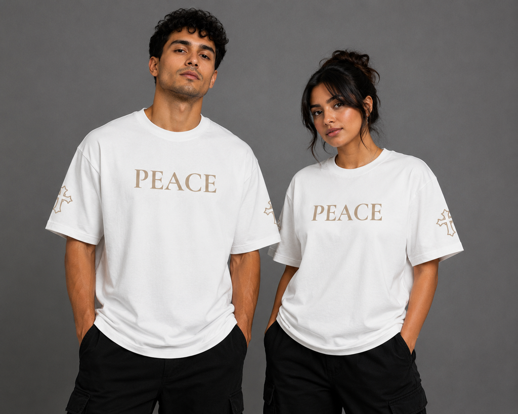 Male and female models wearing white Peace T-shirts with embroidered PEACE chest lettering and embroidered cross sleeve details from the Soul Kreations Luxe Promise Collection.