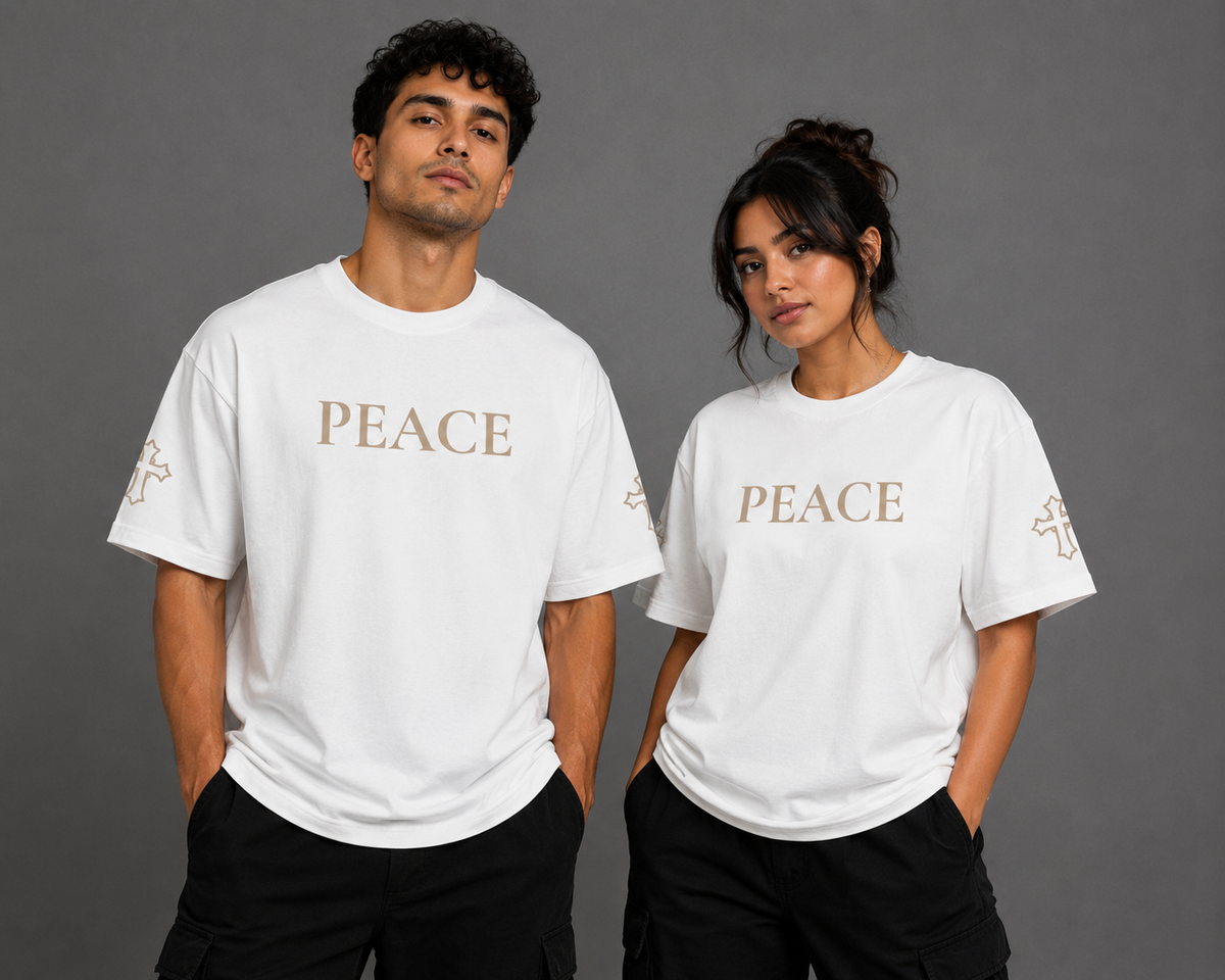 Male and female models wearing white Peace T-shirts with embroidered PEACE chest lettering and embroidered cross sleeve details from the Soul Kreations Luxe Promise Collection.