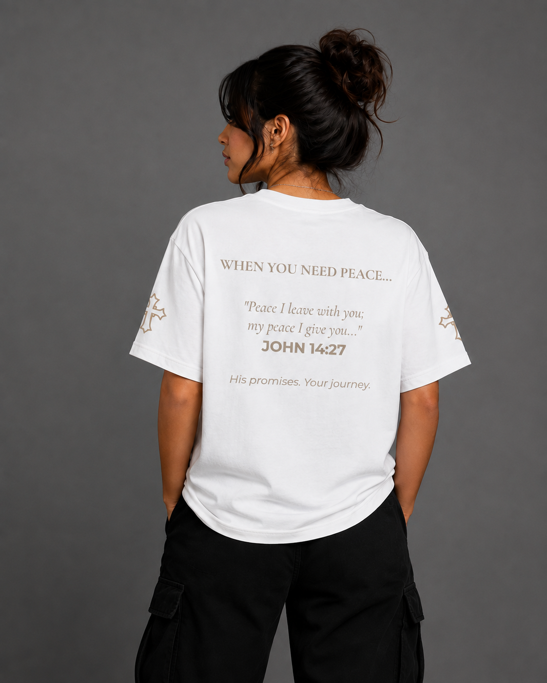 Female model wearing white Peace T-shirt from the Soul Kreations Luxe Promise Collection, featuring John 14:27 scripture printed on the back and embroidered cross details on the sleeves.