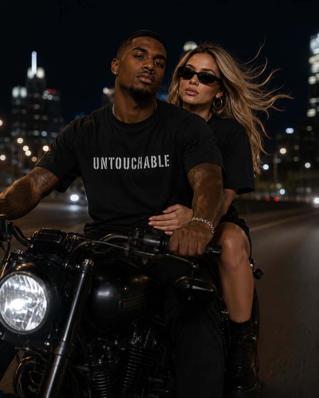 Male and female models wearing matching black “UNTOUCHABLE” graphic T-shirts while 