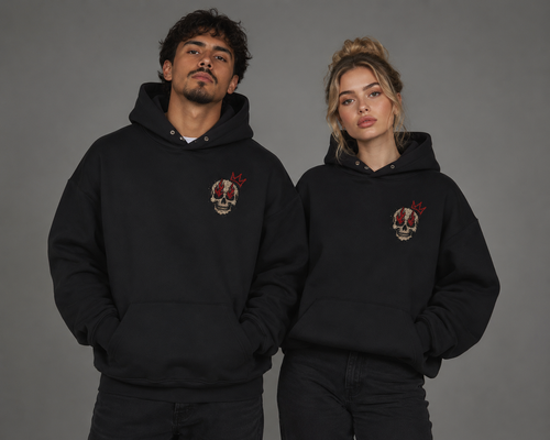 Male and female models wearing black “Built for Chaos” hoodies with a small distressed skull and red crown graphic on the chest.