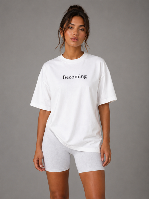 Woman wearing white oversized Becoming graphic T-shirt front view