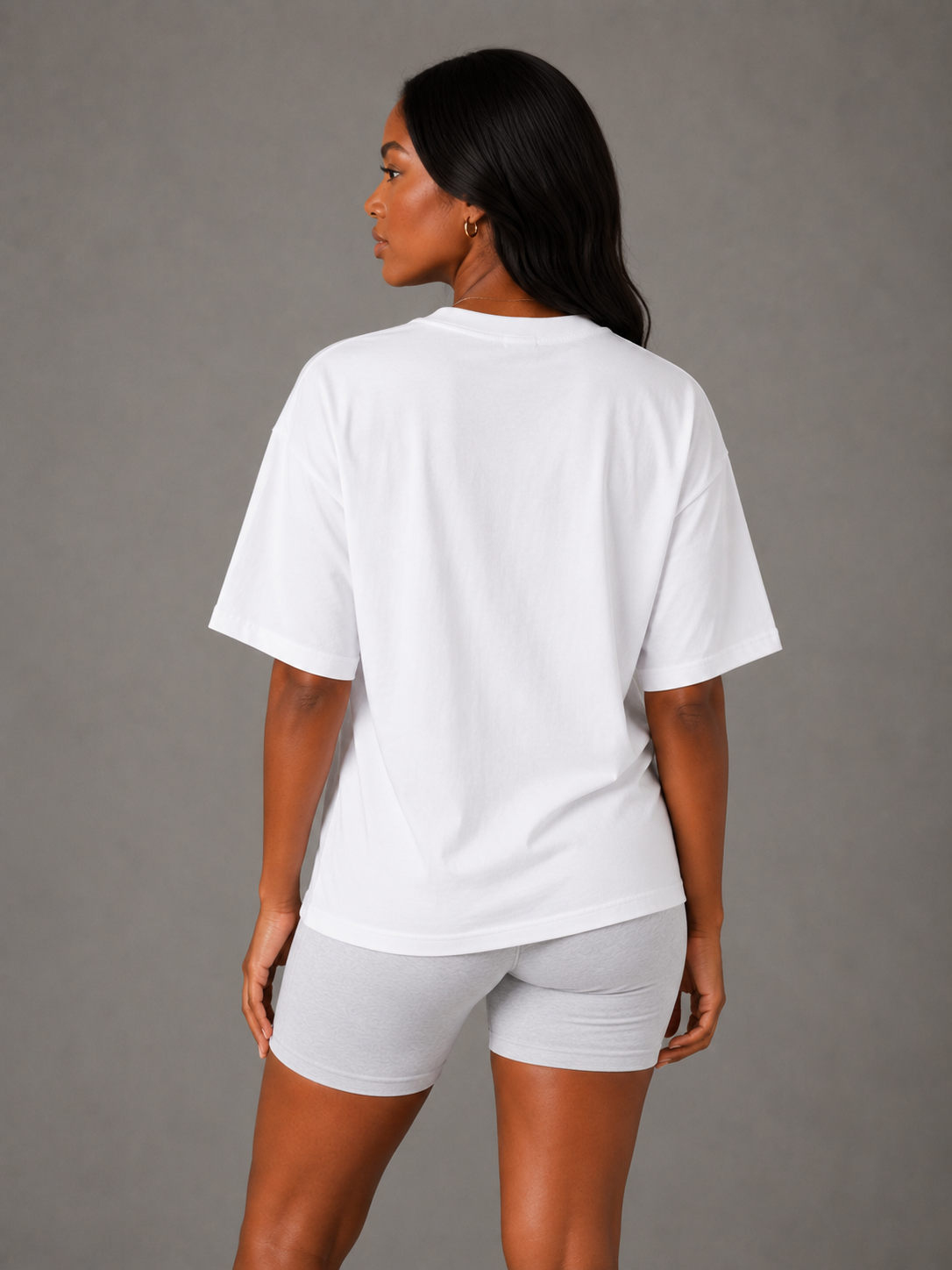 Back view of woman wearing white oversized Peace Over Pressure T-shirt