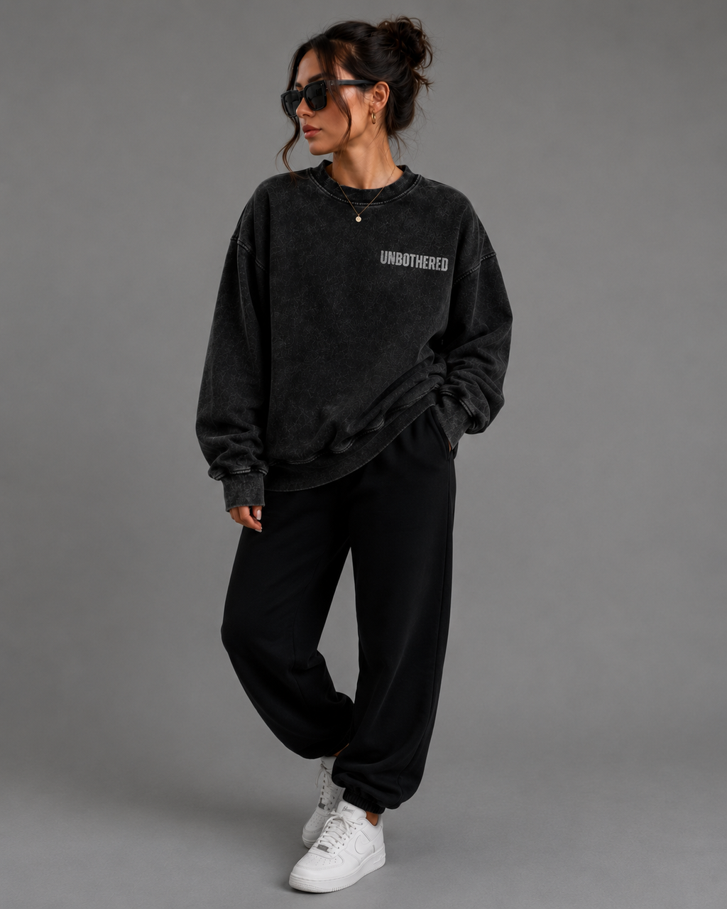 Woman modeling black washed oversized Unbothered sweatshirt with embroidered chest design