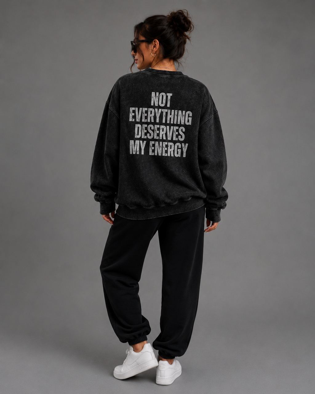 Woman modeling black washed Unbothered sweatshirt with “Not Everything Deserves My Energy” back graphic