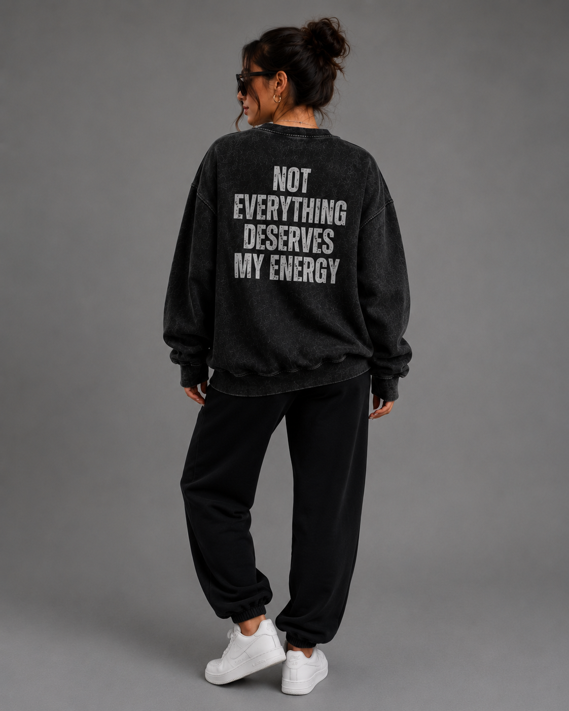 Woman modeling black washed Unbothered sweatshirt with “Not Everything Deserves My Energy” back graphic