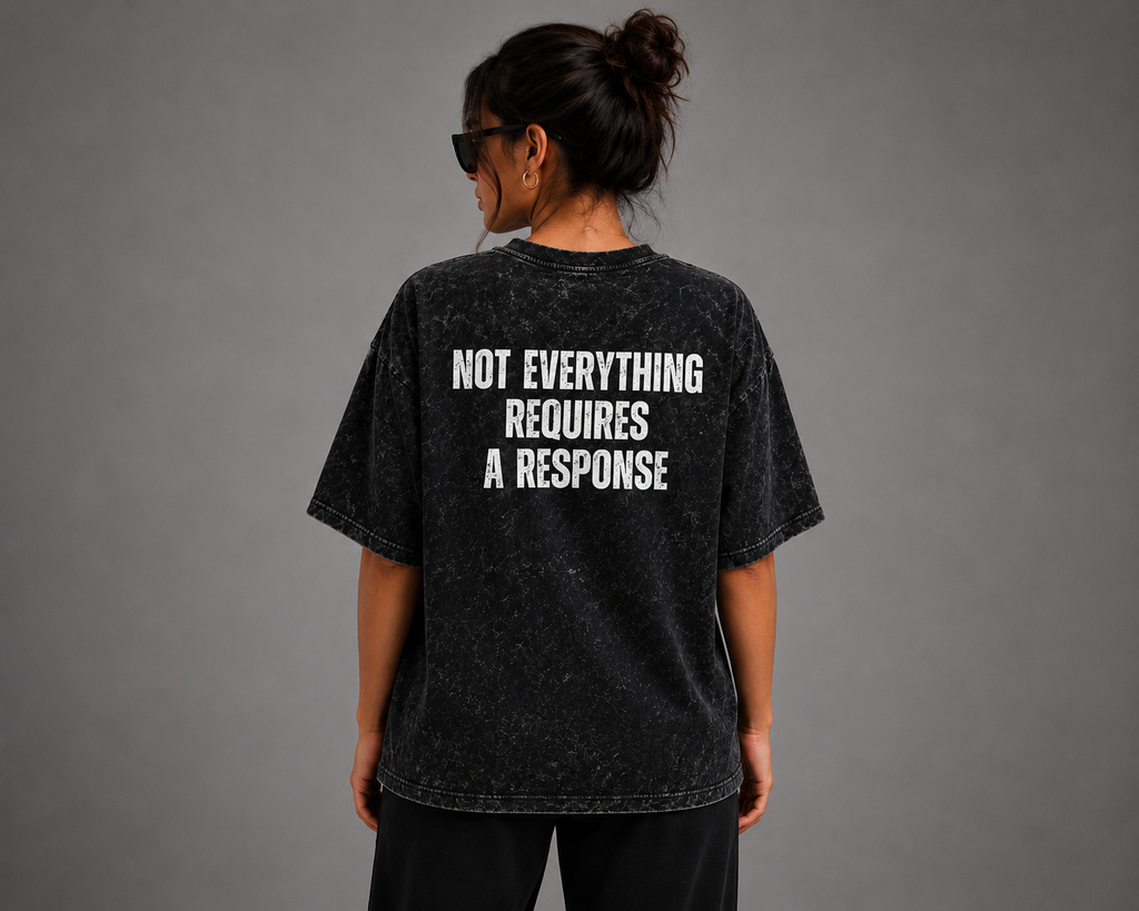 Woman wearing black washed oversized graphic T-shirt with “Not Everything Requires a Response” back design