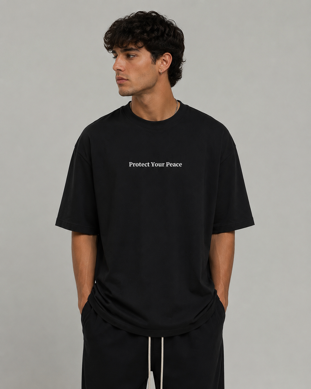 Man wearing black Protect Your Peace oversized T-shirt by Soul Kreations Luxe