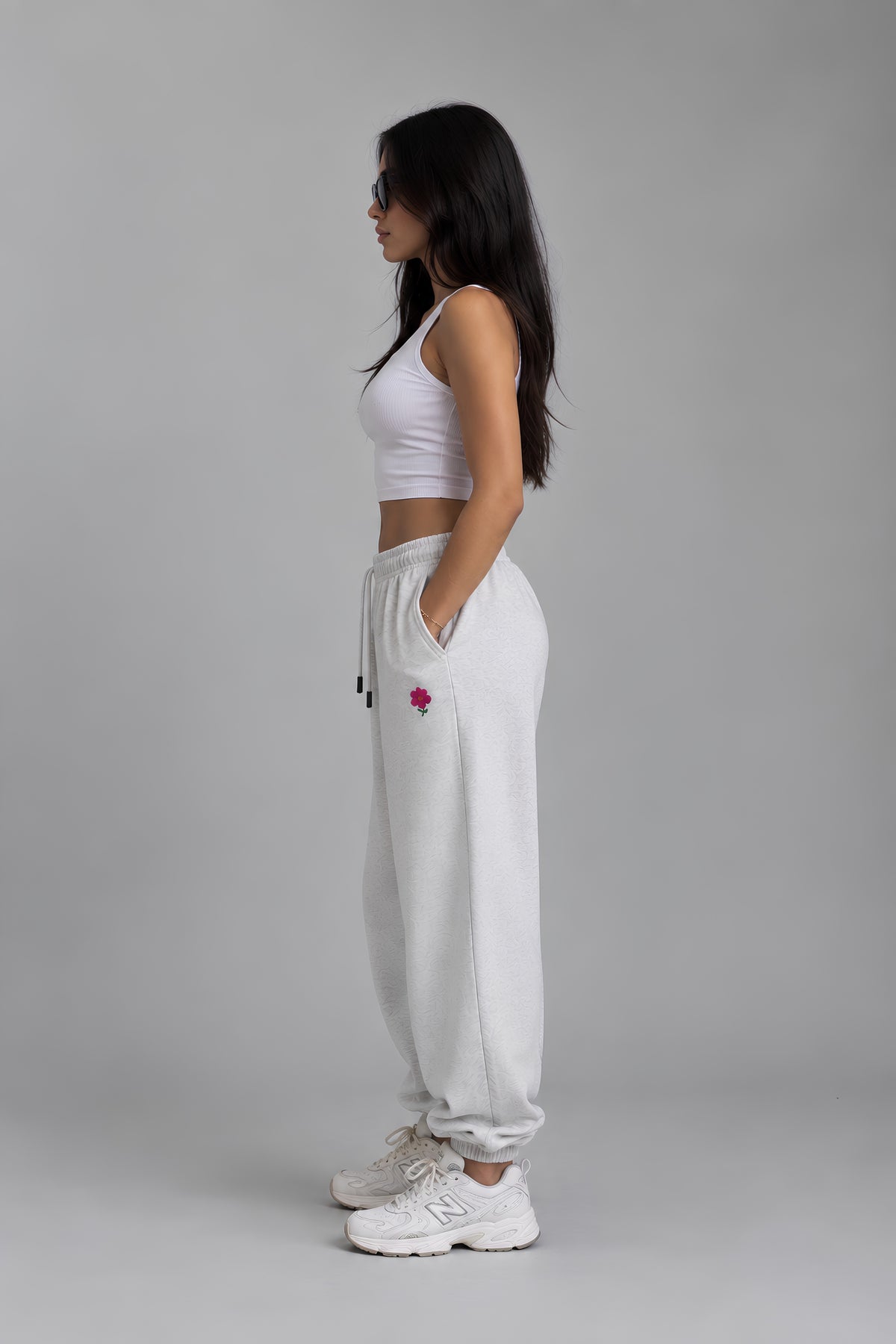 Side view of light heather gray  embroidered sweatpants with pink flower detail